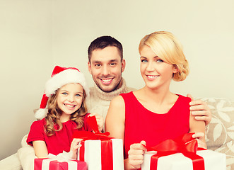 Image showing smiling family holding many gift boxes