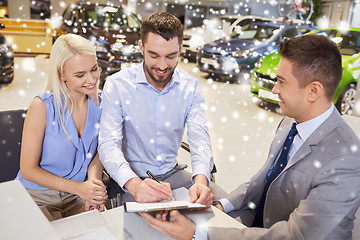 Image showing happy couple with car dealer in auto show or salon