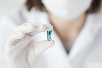 Image showing close up of scientist holding pill in lab