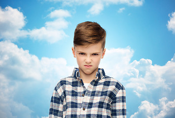 Image showing angry boy in checkered shirt over blue sky