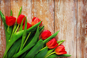 Image showing close up of red tulips on wooden background