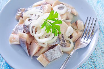 Image showing herring with onion on blue plate