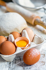Image showing Tray with eggs, dough and rolling pin.