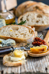 Image showing Rural lunch with bread, cheese and sun-dried tomatoes.