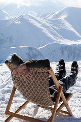 Image showing Skier at winter mountains resting on sun-lounger