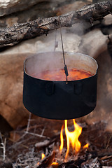 Image showing Pot with soup cooking on campfire