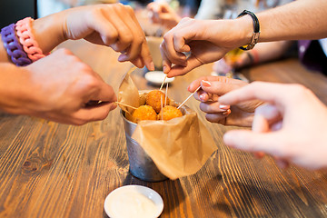 Image showing close up of people hands taking cheese balls