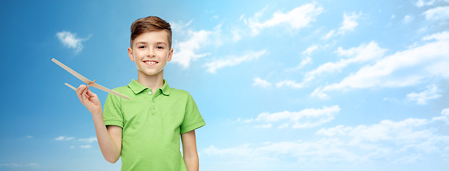Image showing happy boy in green polo t-shirt with toy airplane