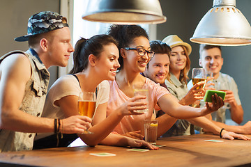 Image showing happy friends with smartphone taking selfie at bar