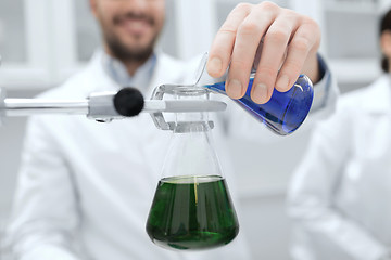 Image showing close up of scientist filling test tubes in lab