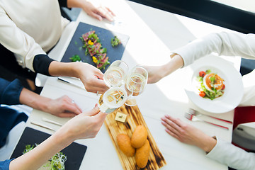 Image showing close up of women clinking champagne at restaurant