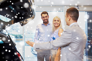 Image showing happy couple with car dealer in auto show or salon