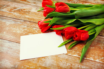 Image showing close up of red tulips and blank paper or letter