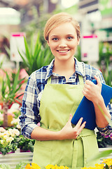 Image showing happy woman with tablet pc in greenhouse