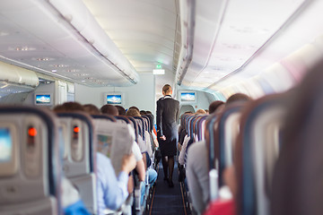 Image showing Stewardess and passengers on commercial airplane.