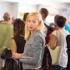 Image showing Young blond caucsian woman waiting in line.