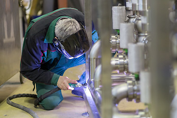 Image showing Industrial worker welding in metal factory.