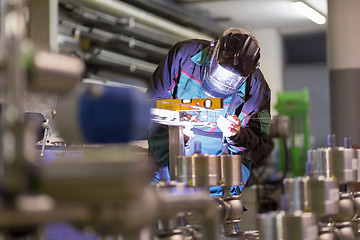 Image showing Industrial worker welding in metal factory.