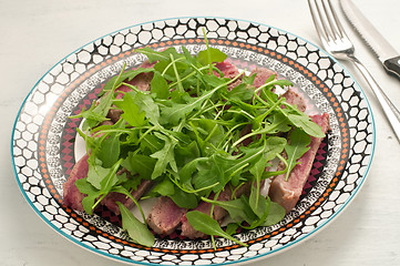 Image showing Sliced beef cooked in the oven with salt, pepper and rocket