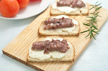 Image showing Crispy bruschetta topped with sausage and fresh rosemary