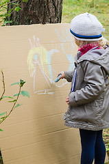 Image showing Girl drawing with crayons on cardboard