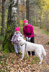 Image showing Granny with her granddaughter and a dog walk in Park  