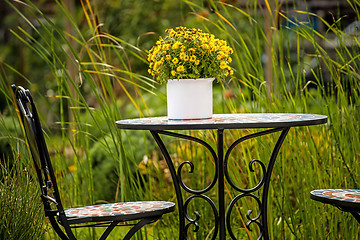 Image showing Garden with desk and bouquet of flowers