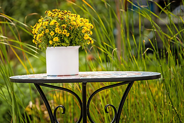 Image showing Garden with desk and bouquet of flowers