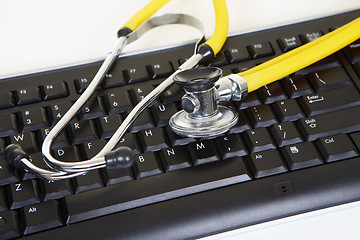 Image showing Yellow phonendoscope and black keyboard