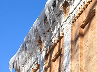 Image showing Snow-covered roof of old house with icicles