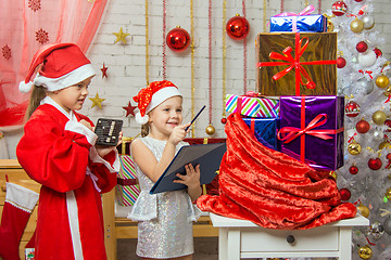 Image showing Santa and helper happily recount gifts in a bag and checked against the list