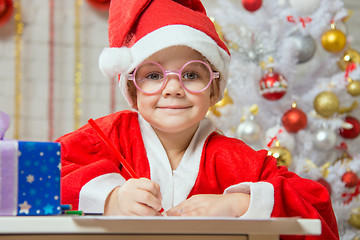 Image showing The girl looked into the frame drawing Gift card as a gift for Christmas