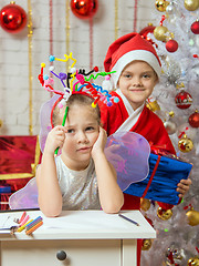 Image showing Girl sits at a table with fireworks on the head, santa claus her ready to give her a gift