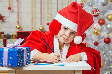 Image showing The girl with enthusiasm draws a Christmas card