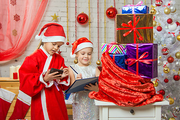 Image showing Santa and helper find gifts in a bag