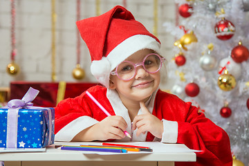 Image showing Girl dressed as Santa Claus with glasses and drawing card for Christmas