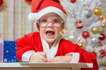 Image showing Girl screams happily drawing Gift card as a gift for Christmas