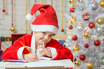 Image showing Girl dressed as Santa Claus thought about the desired Christmas gifts