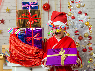 Image showing Girl with fireworks rolling in from the eyes is a gift from bag of Christmas gifts