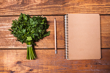 Image showing Blank notebook and pencil with a bunch of herbs on wooden table