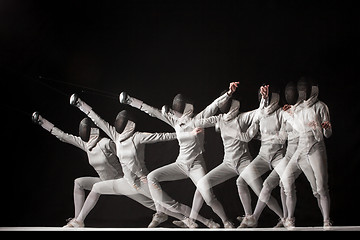 Image showing Full-length portrait of woman wearing white fencing costume  on black 