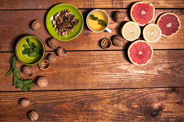 Image showing Lemon and walnut on a wooden surface close up