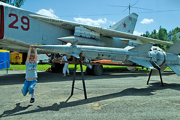 Image showing Boy plays with rocket for military airplane