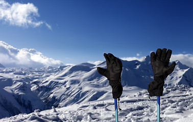 Image showing Gloves on ski poles and snowy mountain 