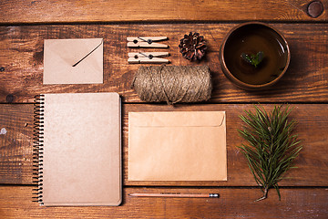 Image showing Notebook for recipes, paper envelopess, rope and clothespins on wooden table.