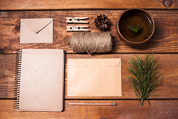 Image showing Notebook for recipes, paper envelopess, rope and clothespins on wooden table.