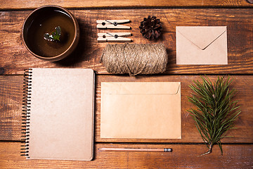 Image showing Notebook for recipes, paper envelopess, rope and clothespins on wooden table.