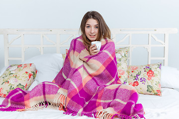 Image showing Sick woman covered with blanket holding cup of tea