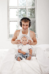 Image showing young father with his nine months old som on the bed at home