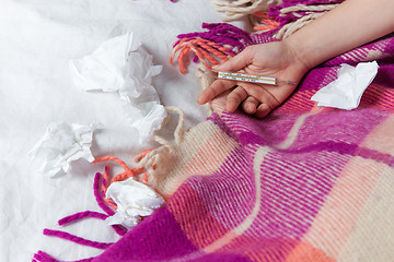 Image showing The hand of young sick woman with thermometer 